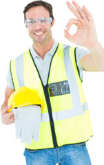 Carpenter holding gloves and hardhat while gesturing OK
