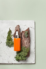 Beauty face serum flatlay with wood and moss on the foreground copy space, earthy tones - 588530787