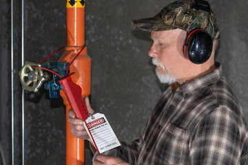 man applying lockout tagout on ammonia valve