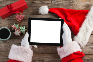 Santa claus holding digital tablet on wooden plank