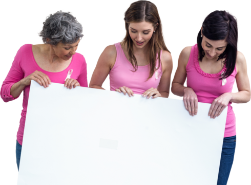 Women in pink outfits holding board for breast cancer awareness