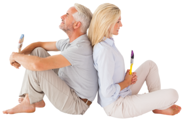 Couple sitting while holding paint brush