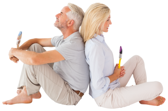 Couple sitting while holding paint brush - Powered by Adobe