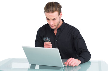 Businessman looking at laptop with magnifying glass