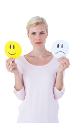 Serious woman holding sad and happy smileys