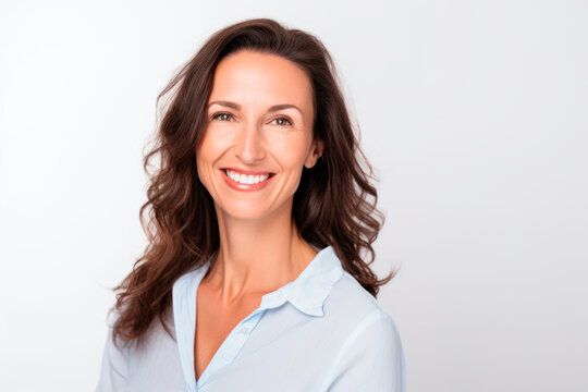Smiling happy woman with long brunette hair in light blue blouse in her 40s on white background. Generative AI
