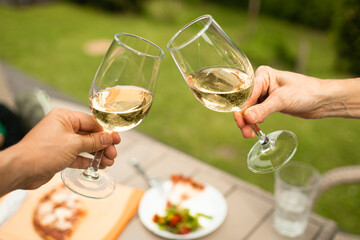 Closeup of could toasting wine glass in the garden 
