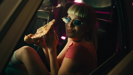Girl eating pizza in car.