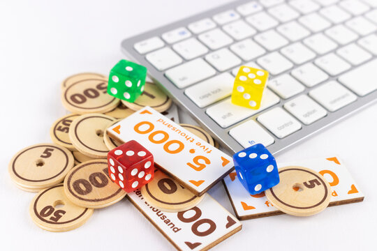 キーボードとサイコロと玩具のサイコロ。オンラインでギャンブルを行うイメージ