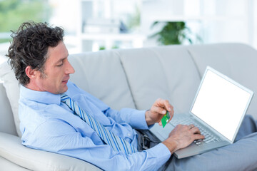 Businessman doing online shopping on couch