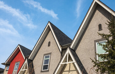 Roof shingles on top of the house against blue sky. Dark asphalt tiles on the roof background. black shingles, roof tile