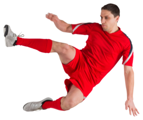Fit football player jumping and kicking