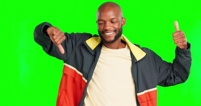 Hand gesture, opposite and review with a black man on a green screen background in studio to give his opinion. Survey, vote and feedback with a handsome young african american male saying yes or no