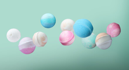Many different bath bombs falling on pastel turquoise background, banner design