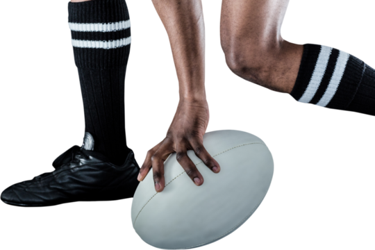 Low section of athlete holding ball while running