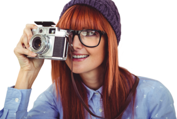 Smiling hipster woman taking pictures with a retro camera