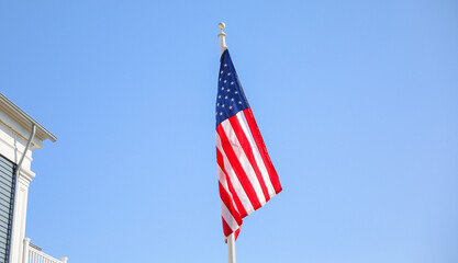 The US flag on a pole is a symbol of patriotism and unity, representing the country's values, history, and people. Its design and colors have symbolic meaning