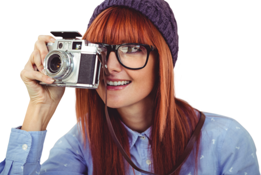 Smiling hipster woman taking pictures with a retro camera