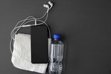 Mat to exercise with the necessary objects such as wireless headphones, cell phone, water to...