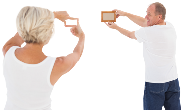 Mature couple hanging up picture frame