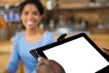 Cropped hands of barista holding digital tablet