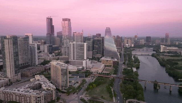 stunning aerial view of Austin's skyline, taken from a drone hovering above the city. In the foreground, you can see the vibrant hues of the Colorado River.