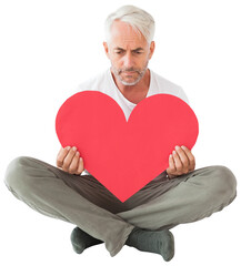 Upset man sitting holding heart shape