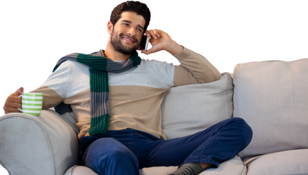 Man talking on phone while having coffee on sofa