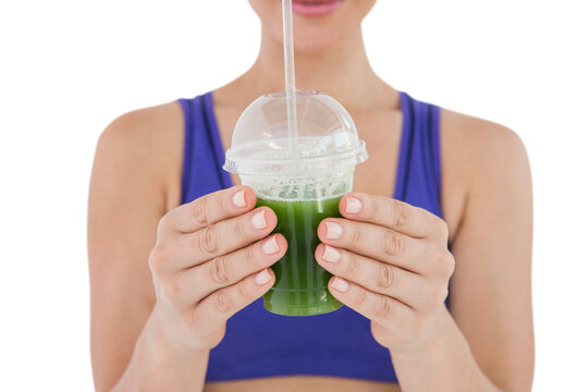 Woman showing green juice in goblet