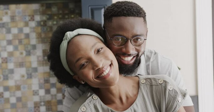 Portrait of happy african american couple embracing in ktichen in slow motion