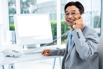 Business man smiling while holding telephone
