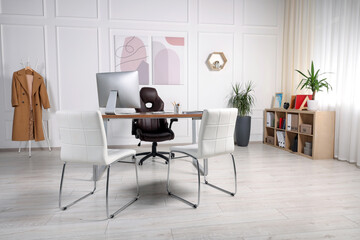 Fototapeta premium Director's workplace with wooden table, computer and comfortable armchairs. Interior design