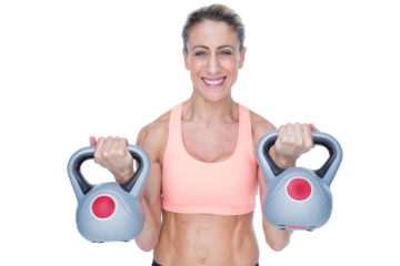 Smiling female crossfitter lifting kettlebells