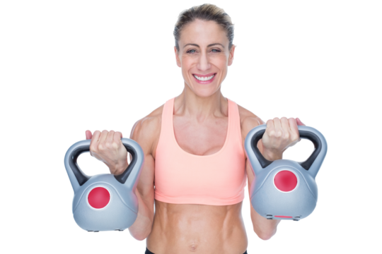 Smiling female crossfitter lifting kettlebells - Powered by Adobe