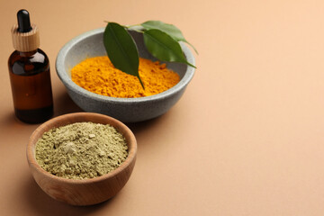 Bottle, henna and turmeric powder on coral background, space for text. Natural hair coloring