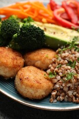 Delicious vegan bowl with cutlets, buckwheat and broccoli on grey table, closeup