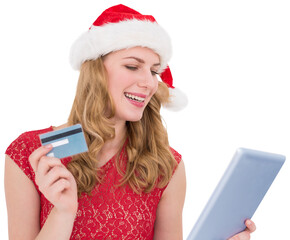 Festive blonde woman using her credit card and tablet pc