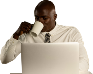 Man drinking coffee while using laptop