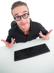 Confused businessman with glasses at desk