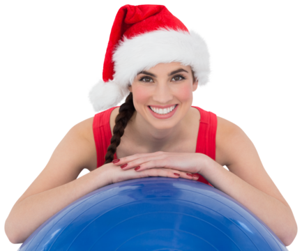 Festive fit brunette leaning on exercise ball