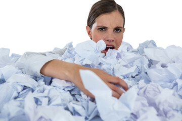 Portrait of unhappy businesswoman in heap crumpled paper