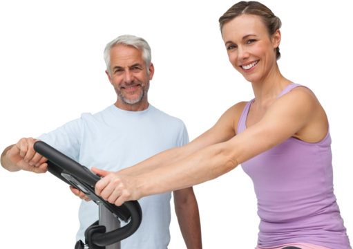 Portrait of a happy woman on stationary bike with trainer - Powered by Adobe