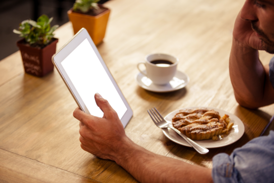 Man looking at digital tablet at cafe
