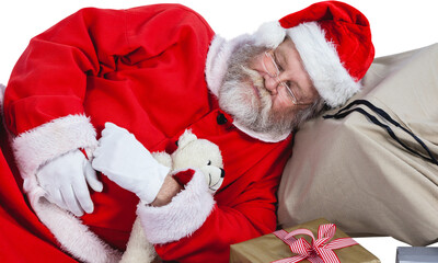 Tired Santa Claus sleeping beside Christmas presents