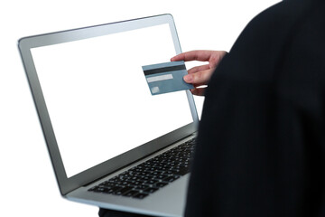 Mid section of hacker using laptop and debit card