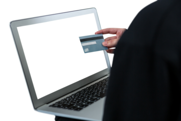 Mid section of hacker using laptop and debit card