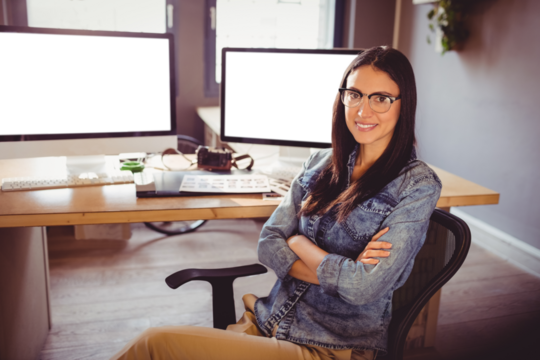 Portrait of happy graphic designer sitting at office - Powered by Adobe