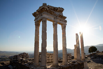 Ruins of the Temple of Trajan the ancient site of Pergamum (Pergamon). Izmir, Turkey. Ancient city columns with the sun in the background.