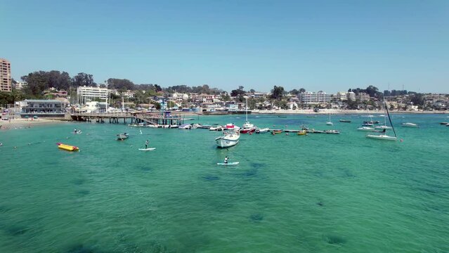 People Paddling On The Pejerrey Beach At Sunny Day In Algarrobo, Chile. aerial, wide