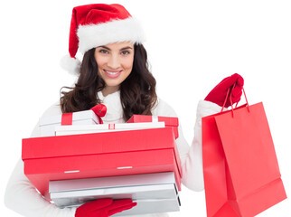 Festive brunette holding christmas gifts and shopping bags